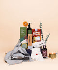 Comfort and Luxuries gift box with alpaca scarf, organic cotton socks, candle, hot chocolate and tea from Canadian small businesses.